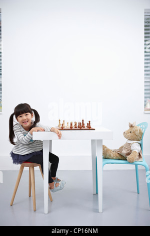 Ein Mädchen spielen Schachspiel mit Teddybär Stockfoto
