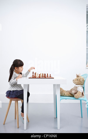 Ein Mädchen spielen Schachspiel mit Teddybär Stockfoto