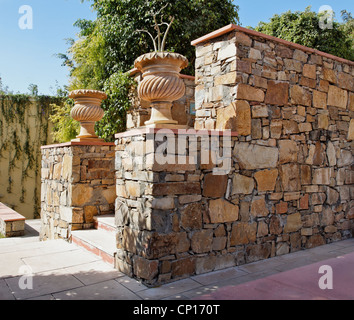 Generische Garten mit Stein geschnitzt Pflanzen Töpfe Amd Randon lokalen Juwels Steinmauer Stockfoto