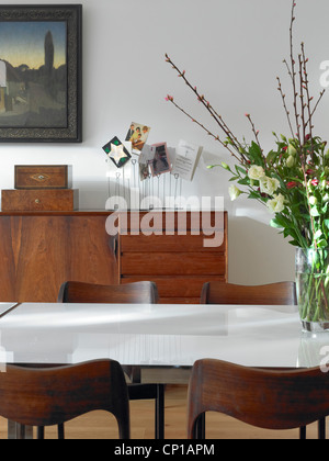 Poliertem Holz Kommode und Stühle mit Schnittblumen auf Tisch im Garden House, UK. Stockfoto