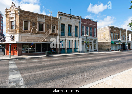 Renovierte Gebäude mit Mann saß auf Bank außerhalb Stadtzentrum San Antonio, Texas. Stockfoto