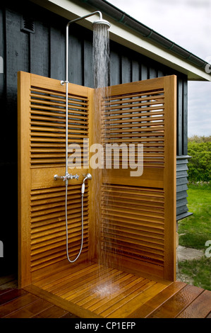 Wasser läuft aus Duscharmatur Einbau in Außendusche mit hölzernen Bildschirme Stockfoto