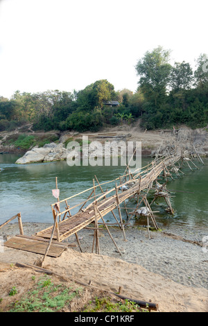 Eine fadenscheinige Bambus Fußgängerbrücke Passerelle de Bambous über Khan River, einem Nebenfluss des Mekong (Luang Prabang - Laos) geworfen. Stockfoto