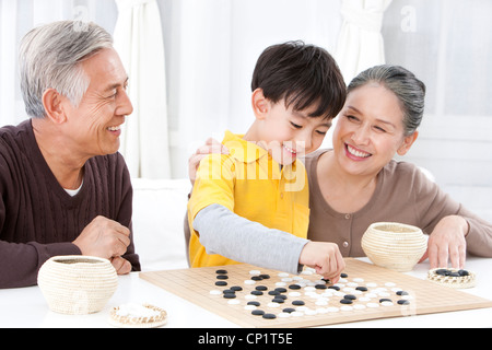 Großeltern und Enkel spielen chinesischer Weiqi Stockfoto