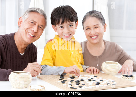 Großeltern und Enkel spielen chinesischer Weiqi Stockfoto