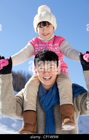 Vater mit Tochter im Schnee spielen Stockfoto
