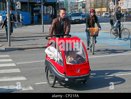 Mann auf Träger Fahrrad mit einem kleinen Mädchen in den vorderen Loadbox überqueren H.C. Andersens Boulevard in der City Hall. Radfahrer-Kopenhagen, Dänemark. Stockfoto