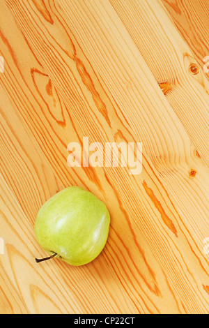 Ein grüner Apfel auf glatten Brettern. Ansicht von oben Stockfoto