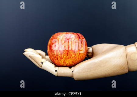 Stillleben Apfel in hölzernen Hand vor einem dunklen Hintergrund Stockfoto