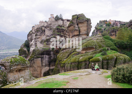 Paar in der Meteora picknicken. Varlaam Kloster auf der linken Seite, Grand Meteoron auf der rechten Seite. Stockfoto