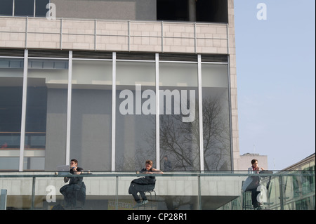 Menschen sitzen und genießen Sie über Internet außerhalb von South Bank centre Stockfoto