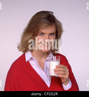 Junge blonde Frau Glas Milch, Berkshire, England, Vereinigtes Königreich Stockfoto