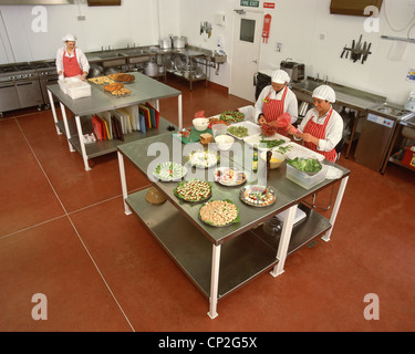 Junge Frauen, die Zubereitung von Speisen in der Küche, Surrey, England, Vereinigtes Königreich Stockfoto