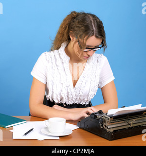 Süße weibliche Autor mit Vintage Schreibmaschine schreiben etwas Stockfoto