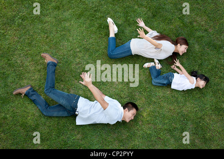 Junge chinesische Familie spielen auf dem Rasen, die vorgibt, fliegen Stockfoto