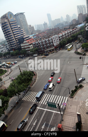 Es ' eine Kreuzung in Shanghai. Wir sehen einige Autos an der Ampel Ans einigen typischen Häusern im Hintergrund wartet. Stockfoto