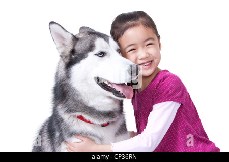 Niedliche kleine Mädchen spielen mit einem Husky Hund Stockfoto