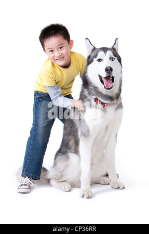 Niedliche kleine Junge spielt mit einem Husky Hund Stockfoto