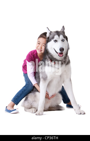 Niedliche kleine Mädchen spielen mit einem Husky Hund Stockfoto