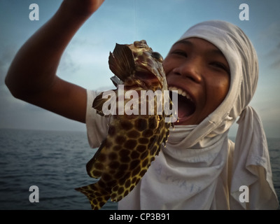 Koh Samui, Hai-Bucht, junge Fischer mit einem nicht essbare tropische Fische spielen. Stockfoto