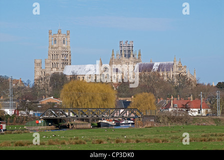 Ely Kathedrale gesehen aus Süden mit Eisenbahnbrücke über den Fluss Great Ouse in Vordergrund Frühlingssonne mit blauem Himmel Stockfoto