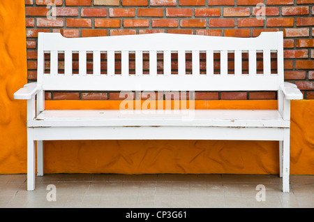 Die Bank weiß und gegen Mauer Stockfoto