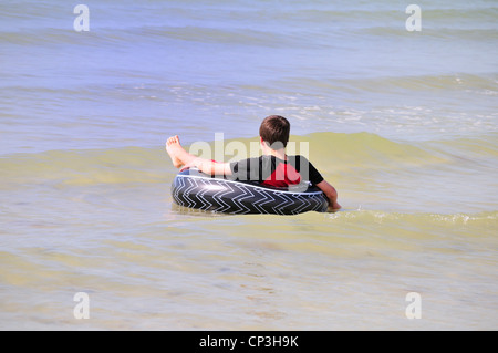 Entspannung in ein Innenrohr in Fort Myers Beach Boy Stockfoto