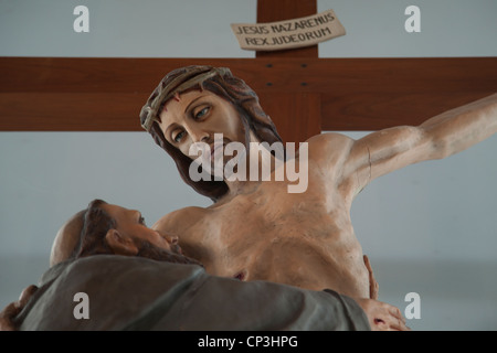 Statue des Heiligen Franziskus von Assisi umarmt Christus am Kreuz in einer katholischen Kirche in St. Hubert, Quebec, Kanada. Stockfoto