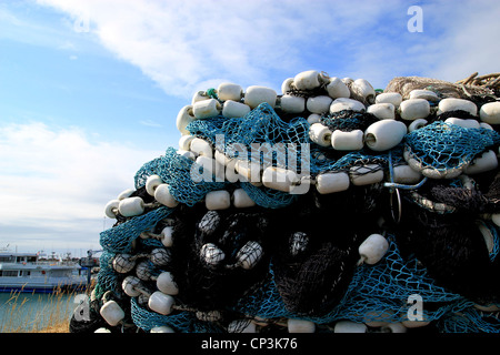 Große Haufen von bunten Fischernetze mit Schwimmern am Hafen in Vorbereitung für kommerzielle Fangsaison. Stockfoto