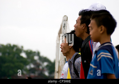 Eine Gruppe von Fußball (Fußball) Fans jubeln an der Seitenlinie auf ein Spiel am Ufer des Mekong-Flusses in Vientiane, Laos. Stockfoto