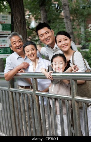 Chinesische Familie an Bushaltestelle Stockfoto