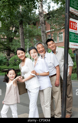 Chinesische Familie an Bushaltestelle Stockfoto