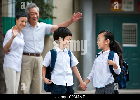Chinesische Schüler mit Großeltern winken Stockfoto