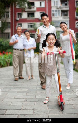 Chinesin mit Roller und Familie auf der Suche auf Stockfoto