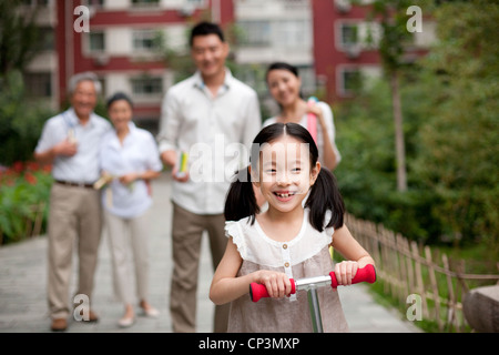 Chinesin mit Roller und Familie auf der Suche auf Stockfoto