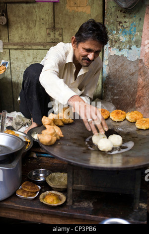 Ein Mann Kochen und servieren Gebratene Kartoffel-Snacks auf den Straßen des Johari Bazaar, Jaipur, Indien Stockfoto