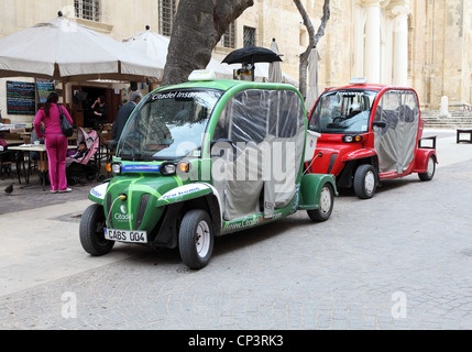 Batteriebetriebene elektrische Taxis geparkt und laden in Valletta, Malta, Südeuropa. Stockfoto