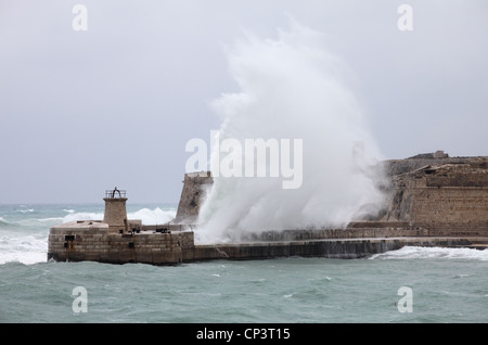 Hafen von riesige Wellen über die Mole am Eingang nach Valletta, Malta, Südeuropa. Stockfoto