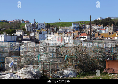 Tintenfische Töpfe Fischernetze auf Hastings Stade mit der Altstadt und West Hill, East Sussex, England Stockfoto