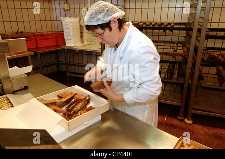 Deutschland - Bremen - Bremerhaven. Franke-Fischerei-Industrie. Eine Frau bereitet Räucherfisch Stockfoto