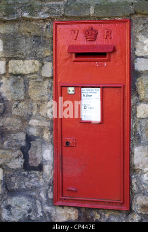 Eine alte rote Briefkasten, eingebettet in eine Steinmauer Stockfoto