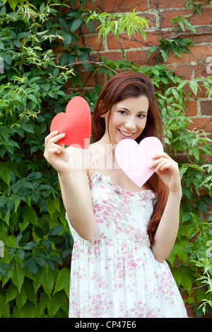 Eine Frau zeigt zwei Herzen Stockfoto