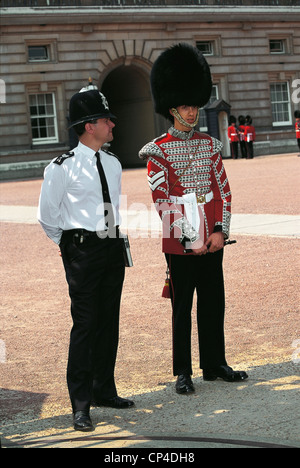 Vereinigtes Königreich - England - London, Buckingham Palace. Eine Wache und ein Polizist. Stockfoto