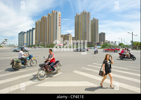 Eine verkehrsreiche Kreuzung entlang einer der wichtigsten Straßen in Datong mit modernen Wohnung Blöcke in den Hintergrund. Stockfoto