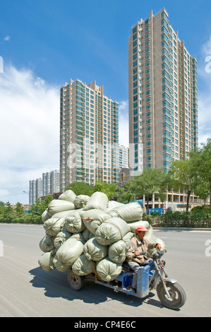 Ein Dreirad mit Gütern, die an einer der Hauptstraßen in Datong unterwegs. Stockfoto