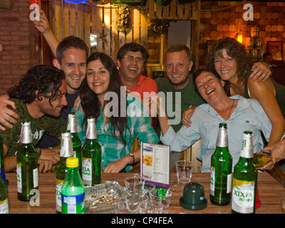 Eine gemischte Altersgruppe (30 bis 60 Somethings) Partei und trinken in einer Bar spät in der Nacht während des Urlaubs. Stockfoto