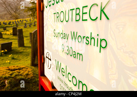 Jesus Church in Troutbeck, Lake District, UK, mit wilden Narzissen blühen in den Kirchhof. Stockfoto