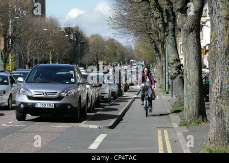 Radsportler, die entlang ein Radweg getrennt von der angrenzenden Straße, The Drive, Hove. Stockfoto