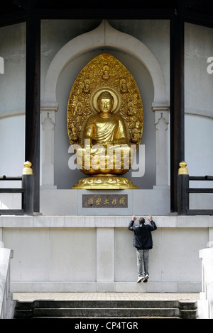 Eine vergoldete Bronzeskulptur des Buddha in der Friedenspagode, Battersea Park, London. (Hängt mit dem Buddha...!) Stockfoto