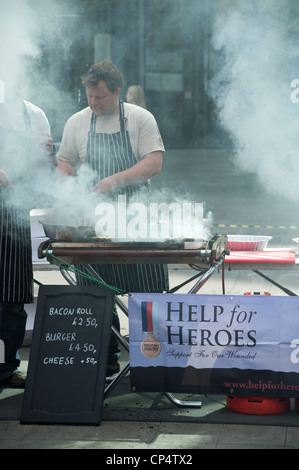 Mann, Kochen auf ein Raucher-Grill an der Hilfe für Helden Nächstenliebe Stand auf den Virgin London Marathon 2012 Stockfoto